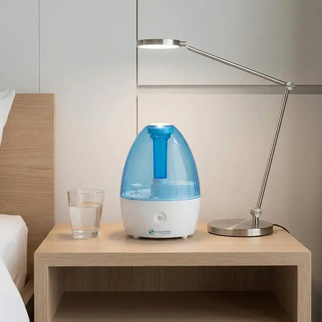 Minimalist nightstand featuring a compact humidifier, lamp, and glass of water to illustrate its small footprint. Minimalist nightstand featuring a compact humidifier, lamp, and glass of water to illustrate its small footprint.